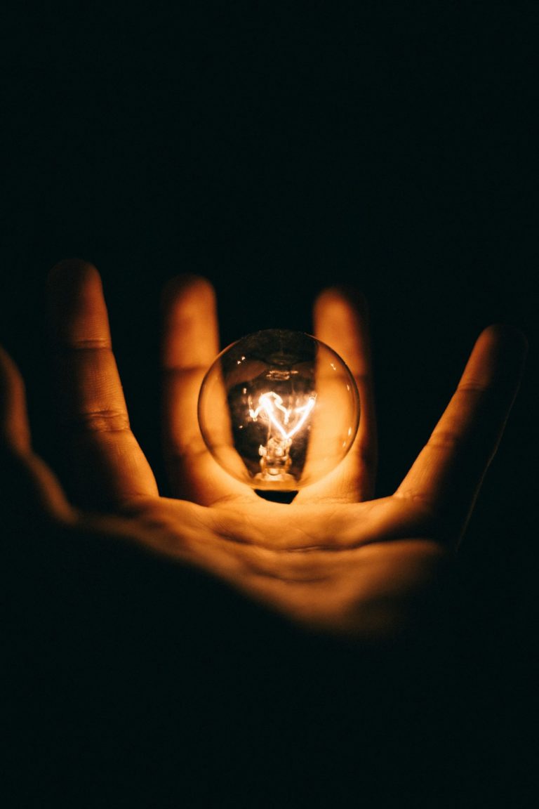 a hand holding a lit up candle