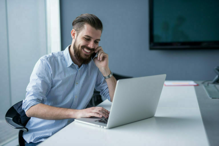 a man on a phone and a laptop